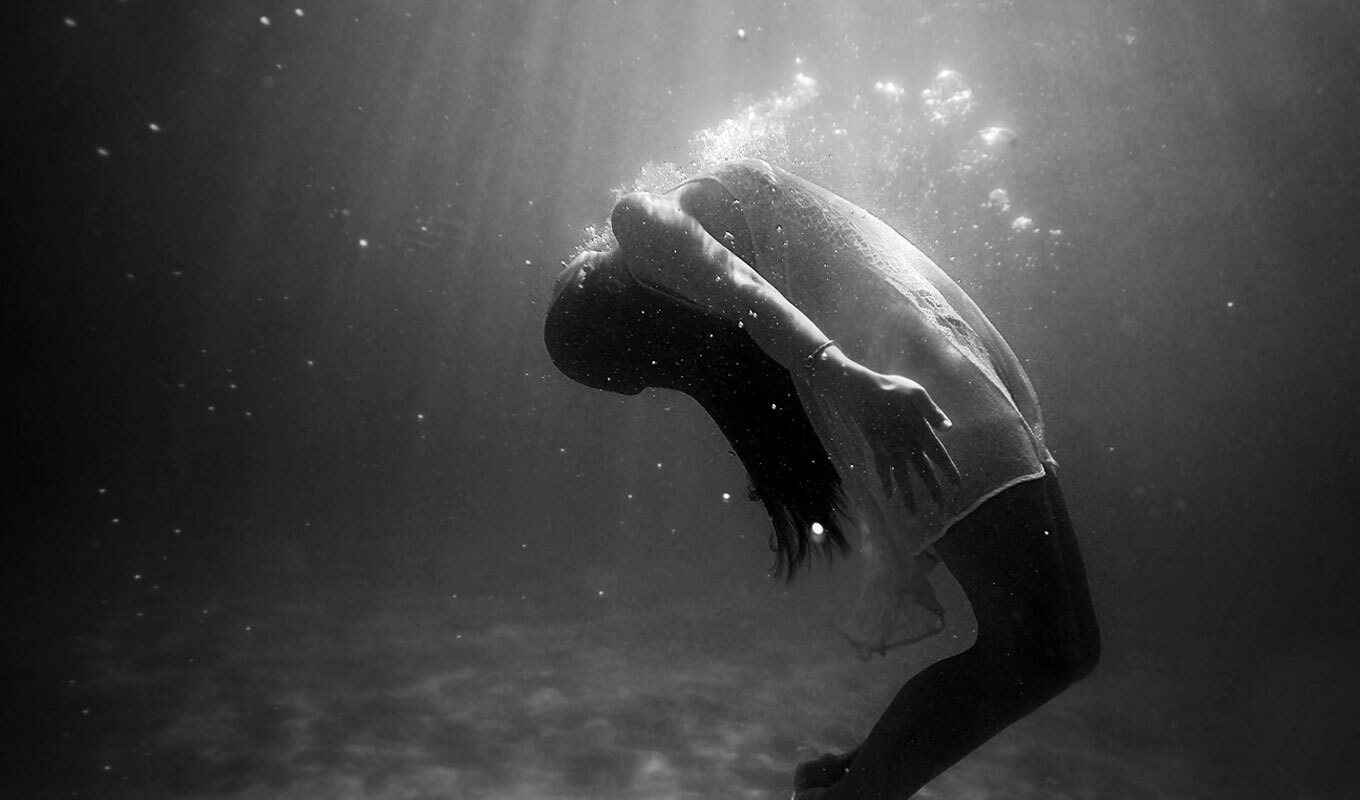 black and white photo of a woman under water, experiencing loneliness in her marriage