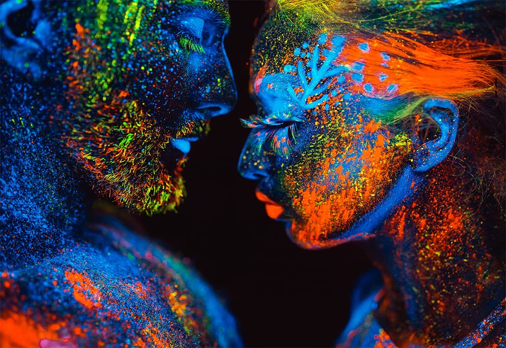 Image Of A Man And Woman In Ultraviolet Powder With Their Eyes Closed And Faces About To Touch