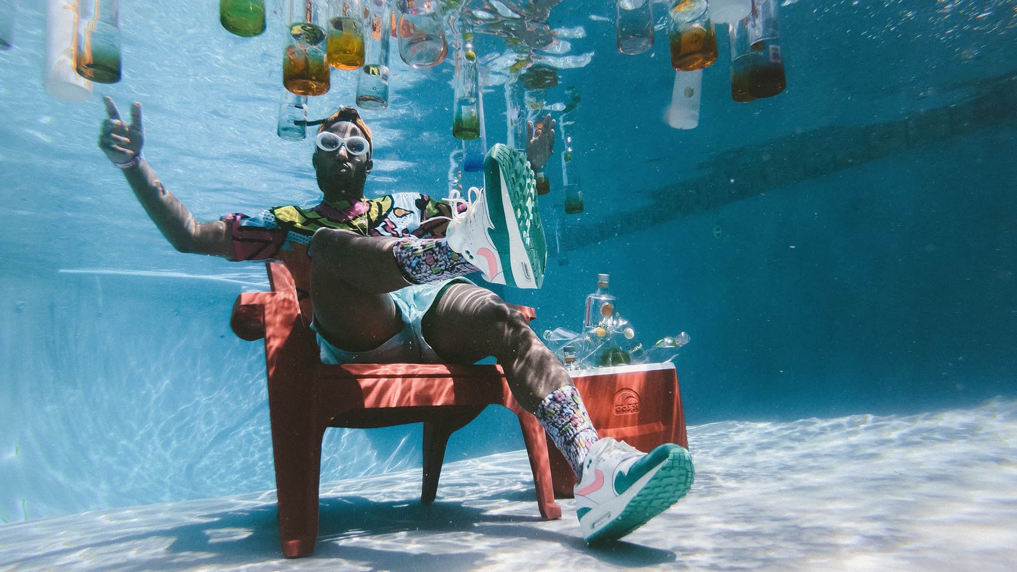 Underwater Photograph Of African American Man Casually Seated At The Bottom Of A Pool, Party Concept
