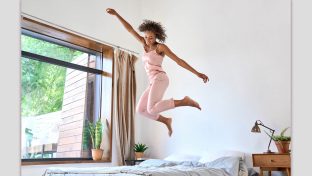 Photograph Of Happy Woman Jumping Up And Down On Her Bed, Lifting Her Spirits When Feeling Alone