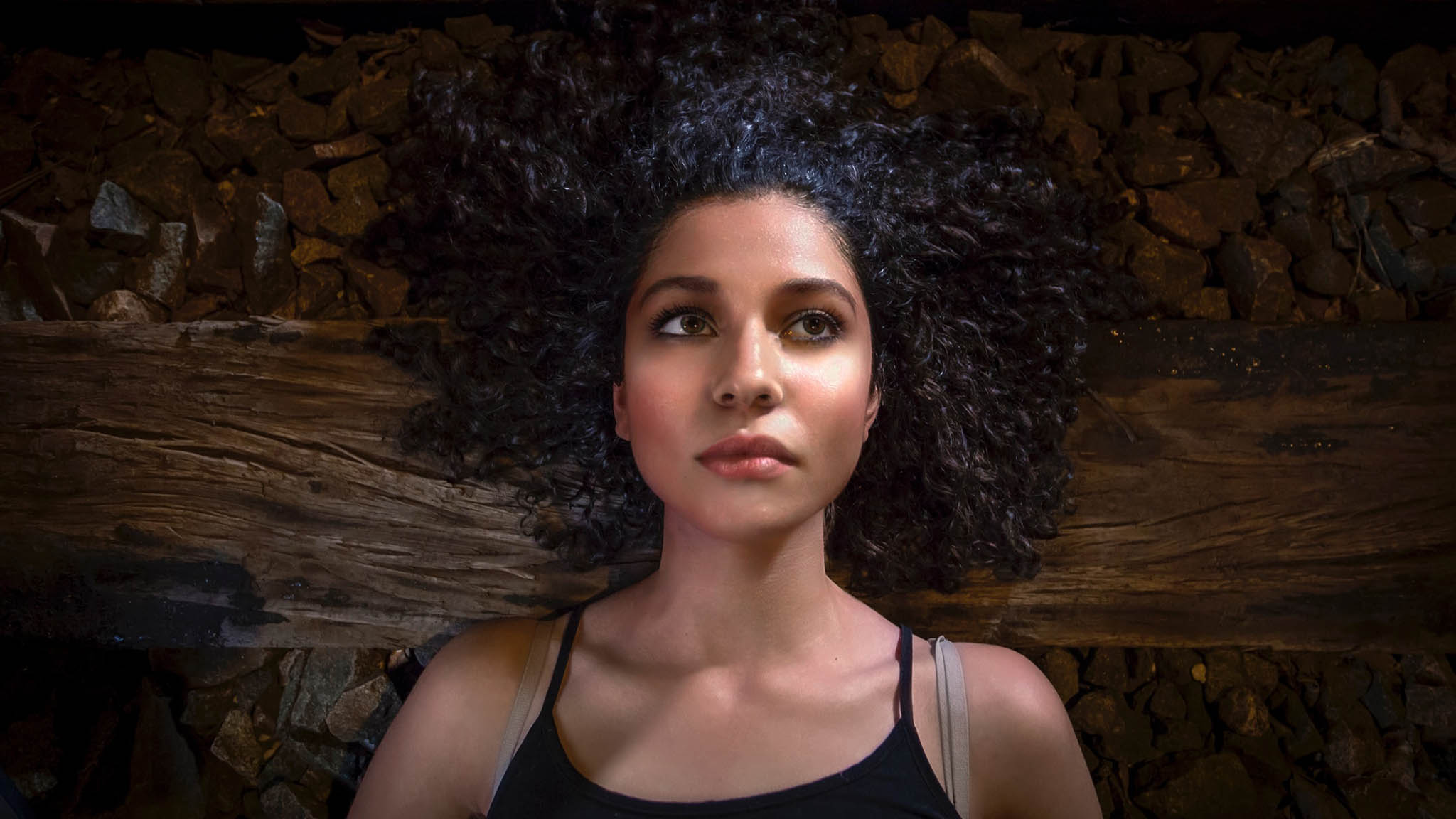 Aerial Photo Of Pensive Young Woman Laying Down On Stone And Wood